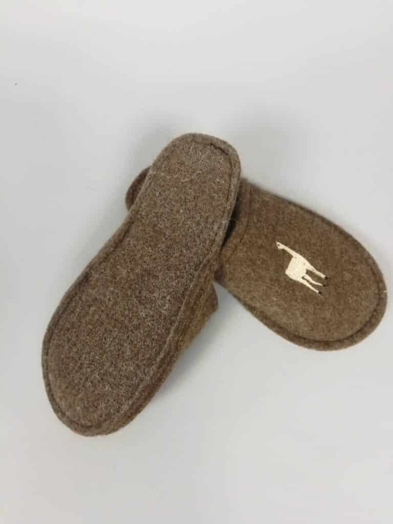 Braune Filzpantoffeln mit einer gestickten Figur auf einem Pantoffel.