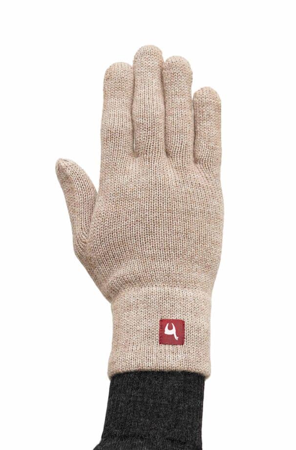 Beiger Strickhandschuh mit einem kleinen roten Logoaufnäher am Handgelenk.