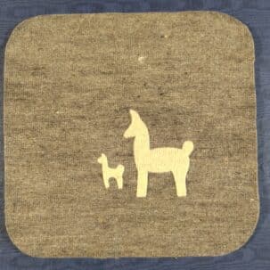 Zwei stilisierte Llama-Silhouetten, eine große und eine kleinere, auf einem grauen rechteckigen Stoff vor blauem Hintergrund.