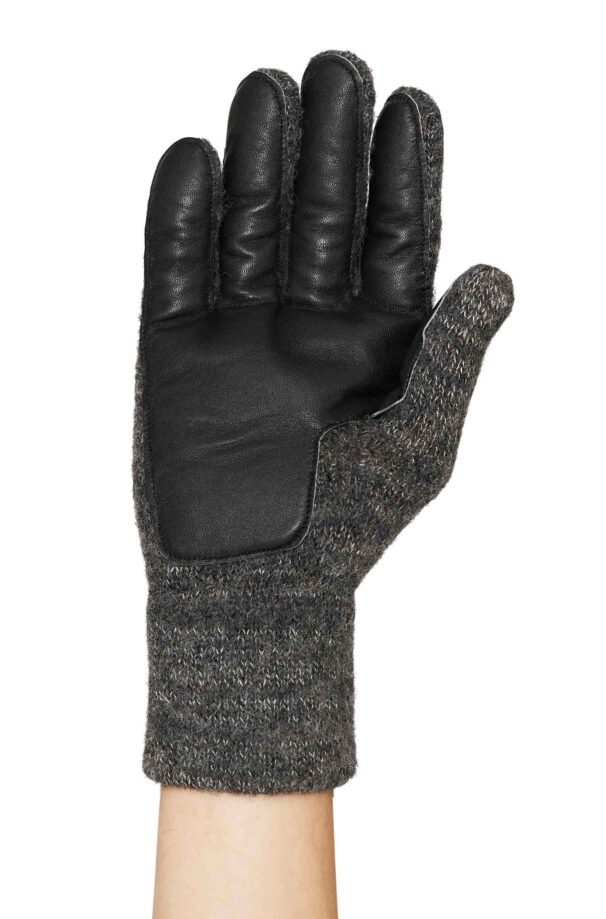 Hand in einem Handschuh aus gestricktem Stoff und Leder auf der Handfläche.