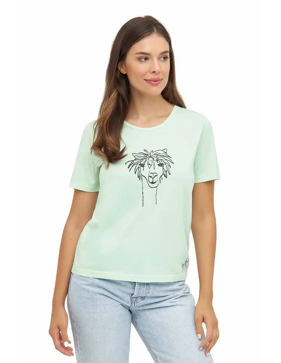 Junge Frau in einem hellgrünen T-Shirt mit einem gezeichneten Löwenmotiv auf der Vorderseite, kombiniert mit hellblauen Jeans.