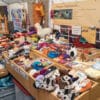 Marktstand mit handgefertigten Wollprodukten, Filzpantoffeln, Garnen und schmuckhaften Accessoires.