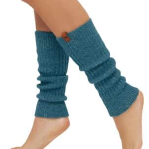 Ein Paar Beine trägt blaue Strickstulpen, die die Waden bedecken und über den Knöcheln enden.