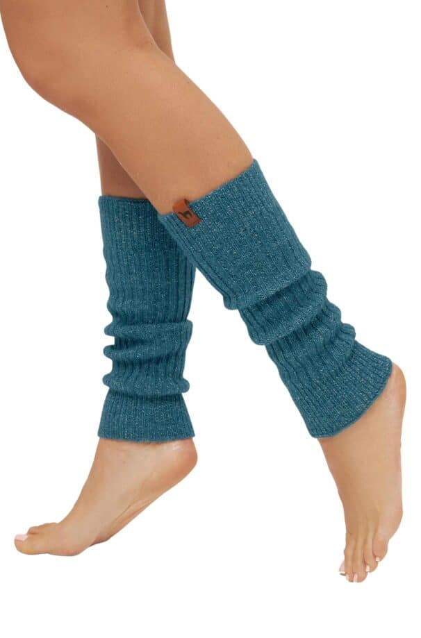 Ein Paar Beine trägt blaue Strickstulpen, die die Waden bedecken und über den Knöcheln enden.