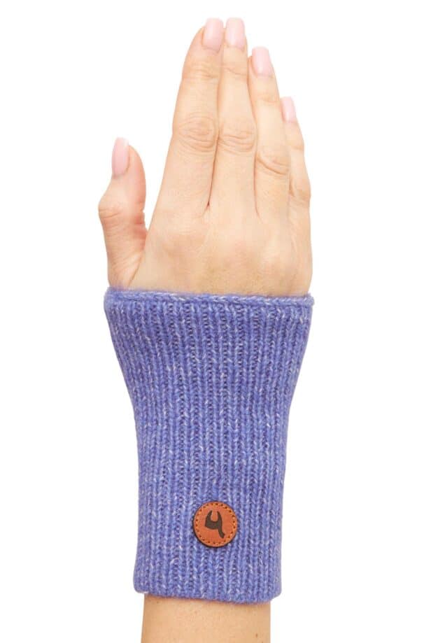 Eine Hand, die einen lilafarbenen gestrickten Pulswärmer trägt, mit einem runden Lederpatch am Handgelenk.
