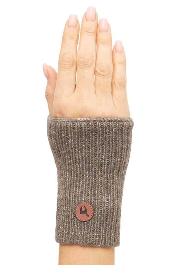 Ein Strick-Handwärmer aus braunem Garn, der einen Teil des Handgelenks bedeckt und mit einem kleinen braunen Lederetikett versehen ist.