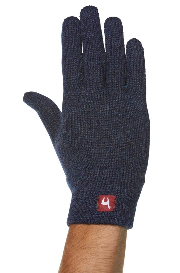 Ein blau gestrickter Handschuh aus Wolle, der auf einer Hand getragen wird, mit einem roten Etikett am Handgelenk.