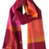Ein farbenfroher Schal mit einem Karomuster in den Farben Rot, Pink, Orange und Gelb, versehen mit einem kleinen Logo-Etikett an einem Ende.