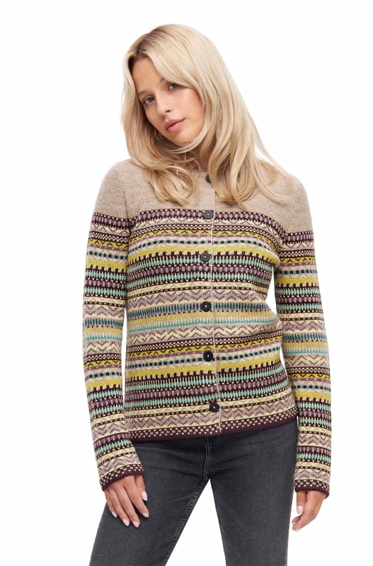 Frau mit blondem Haar trägt einen gemusterten Strickpullover mit Knöpfen und schwarzen Jeans.